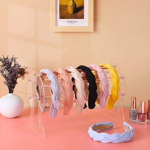 Macro view of thick braided headbands in various colors on acrylic display stand