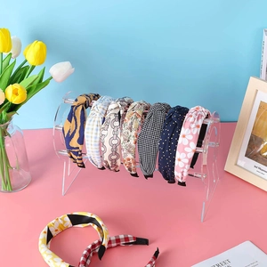 Various patterned headbands displayed on clear acrylic organizer with floral home decor