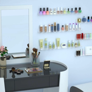 Close-up of wall-mounted clear acrylic organizer shelf displaying nail polish and perfume