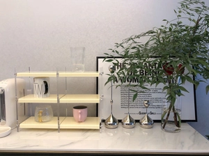 Three-tier cream desktop storage rack with acrylic pillars for mugs and perfume bottles