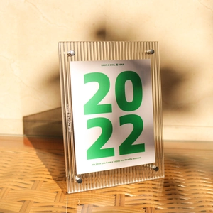 Verticale acryl fotolijst met geribbelde textuur en zilveren schroeven op rotan