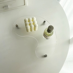 Close-up of irregular wave acrylic tray with three silver metal legs for home decor