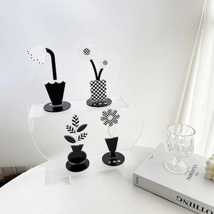 Minimalist acrylic floral desk decor with checkered patterns and clear tiered stand