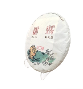 Close-up of 500g Pu-erh tea cake with traditional Chinese label on a clear display stand