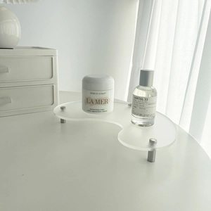 Detail of transparent wavy acrylic tray with sleek metal legs for desktop display