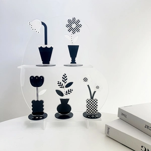 Modern acrylic flower clips with checkerboard and dot patterns on a transparent display stand