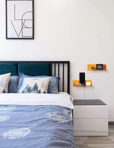 Detail view of orange acrylic floating shelves mounted in a modern bedroom setting