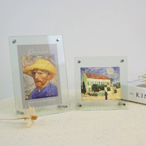 Close-up of clear acrylic picture frame with silver metal support rods on beige linen