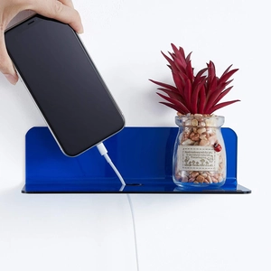 Detail view of L-shaped blue acrylic floating shelf with cable hole for electronics