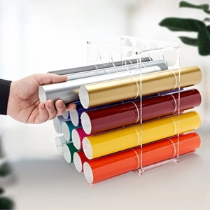 Clear acrylic vinyl roll organizer with 12 holes showing colorful rolls being stored