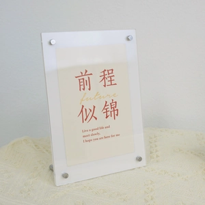 Macro view of transparent acrylic photo frame with metal bolts and artistic insert card