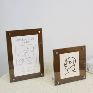 Detail of dark brown acrylic picture frames with elegant silver metal support bolts