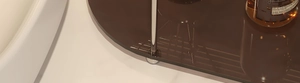 Macro detail of amber acrylic shelf with polished stainless steel support legs