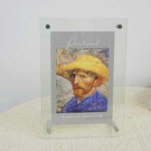 Detail of a clear acrylic photo frame with metal bolts featuring Van Gogh portrait art