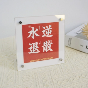 Close-up of acrylic frame with metal screws showing a red Mercury Retrograde card