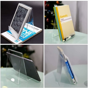 Close-up of a clear acrylic display stand supporting various books and tablets