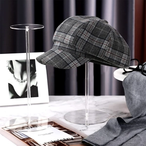 Classic grey plaid newsboy cap on clear acrylic stand with professional display