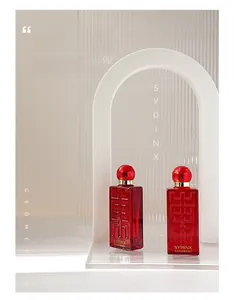 Macro shot of two luxury red glass serum bottles with gem-cut caps behind ribbed glass