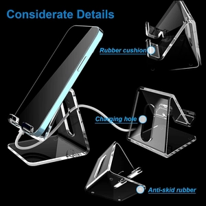Detailed view of acrylic phone stand features with rubber pads and charging port slot