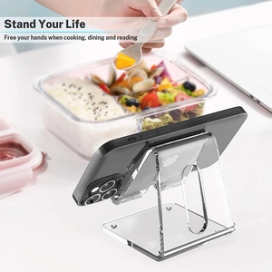 Clear acrylic phone stand on desk during mealtime showing transparent material design