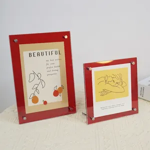 Minimalist red acrylic photo frames with metal screws on a white textured background