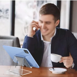 Gros plan d'un support de tablette en acrylique transparent sur une table en bois naturel