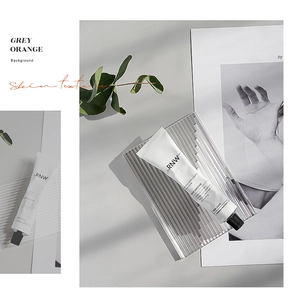 RNW niacinamide hand cream in white tube on a stylish ribbed glass tray with leaves