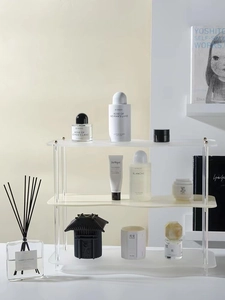 Vista de cerca del soporte de acrílico para perfumes de tres niveles con bordes ondulados