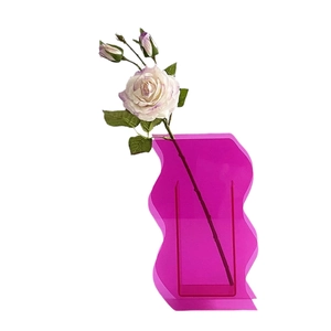 Pink translucent acrylic wave vase with a modern geometric S-shaped decorative design