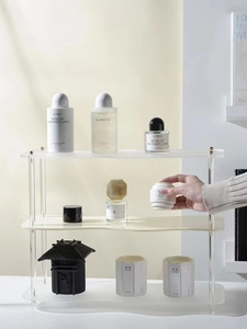 Detalle del estante organizador de acrílico ondulado de tres niveles para perfumes