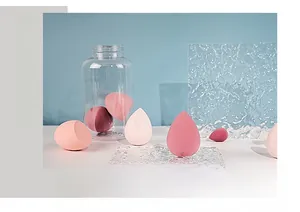Macro shot of pink makeup sponge set on water ripple glass plate and blue background