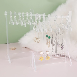 Detail view of transparent acrylic earring organizer with mini clothes hanger design