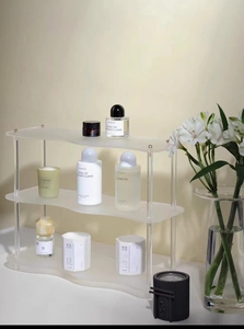Estante de acrílico de tres niveles con bordes ondulados para perfumes y cosméticos