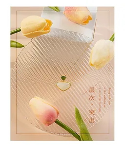 Detailed view of dual-stone heart and shell pendant necklace on glass tray