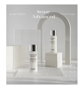 Detail of AHC Hyaluronic skincare bottles with striped acrylic and stone props