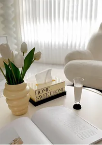 Acryl-Taschentuchbox in Creme mit schwarzem Boden und HOME-Schriftzug auf Tisch
