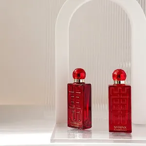 Red SYRINX serum glass bottles on a textured transparent stand in a modern minimalist setting