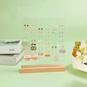 Acrylic earring display stand with wooden base and colorful stud earrings on mint background