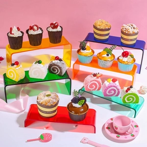 Six présentoirs en acrylique coloré en forme de U exposant divers desserts colorés