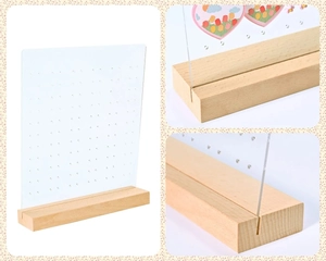 Detailed view of clear acrylic earring organizer with slots and natural wood base stand