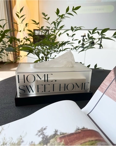 Moderne cremefarbene Acryl-Taschentuchbox mit Text auf schwarzem Ständer im eleganten Wohnstil
