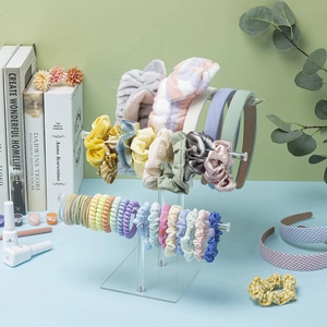 Three-tier clear acrylic T-bar stand displaying colorful scrunchies and headbands