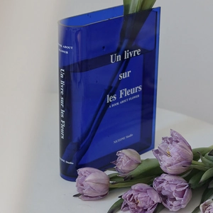 Modern deep blue acrylic book vase with elegant French text and purple tulip flowers