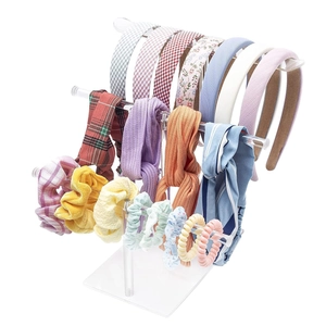 Three-tier clear acrylic display stand with various colorful headbands and hair scrunchies