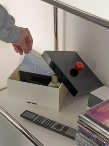 Detail of acrylic storage box with red spherical handle on a metal shelf for masks