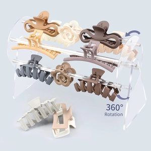 Dettaglio di pinze per capelli opache colori Morandi su supporto girevole in acrilico a 360°