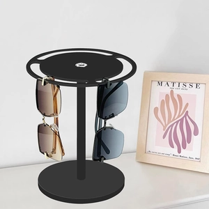 Rotating black matte sunglasses display stand with round base holding four pairs of glasses