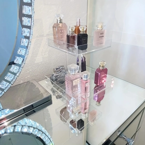 Detail view of double-layer transparent acrylic display stand on a sleek vanity