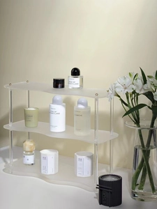 Estante organizador de acrílico ondulado de tres niveles con detalles dorados para perfume