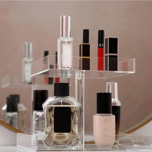 Close-up of a two-tier clear acrylic perfume and cosmetic organizer tray for vanity storage